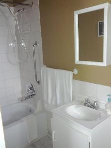 a bathroom with a tub and a sink and a shower at Motel Montgolfière JP in Saint-Jean-sur-Richelieu