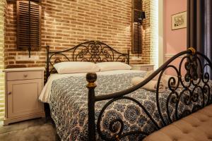 a bed sitting in front of a window next to a wall at Acronafplia Pension B&D in Nafplio
