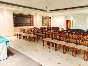 una habitación con un montón de sillas y una pantalla en Hotel Azuay, en Duitama