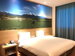 una camera d'albergo con un letto e un grande dipinto sul muro di 綺麗商旅園區館 a Città di Taitung