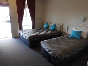 a hotel room with two beds and a window at The Argent Motel in Broken Hill