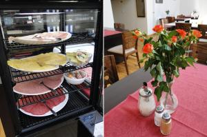 een koelkast met eten en een vaas met bloemen op een tafel bij Hotel De Lange Jammer in Lelystad