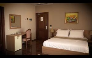 a hotel room with a bed and a desk and a bed at Fishta Hotel & Apartments in Velipojë