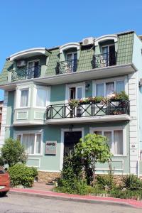 un edificio verde con balcones y flores. en Hotel Elegant Garden, en Batumi