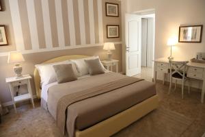 a bedroom with a bed and two tables and a desk at Dimi House in Lecce