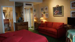 - une chambre avec un lit rouge et un canapé rouge dans l'établissement Le Relais Médicis, à Paris
