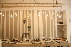 una sala da pranzo con tavolo, sedie e luci di Dimi House a Lecce