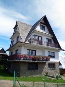 una gran casa blanca con flores en el balcón en Pod Tatarską Górą, en Biały Dunajec