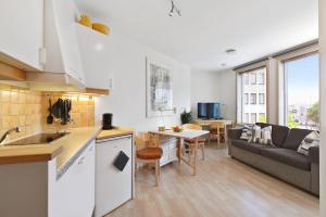 een keuken en een woonkamer met een bank en een tafel bij Frogner House - Fiskepiren in Stavanger
