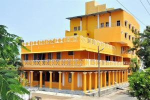 ein gelbes Gebäude mit Balkon darüber in der Unterkunft Hotel Anandhiram Heritage in Kāraikāl