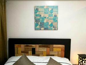 a bedroom with a bed with a picture on the wall at AAA Condominium in Tagaytay +20 photos