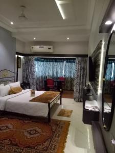 a bedroom with a bed and a table in a room at Prithvi Hotels in Ahmedabad