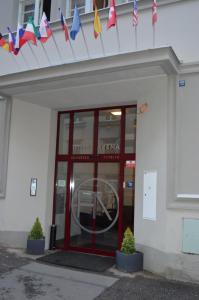 een gebouw met een rode deur met vlaggen erop bij HOTEL ARÉNA in Praag