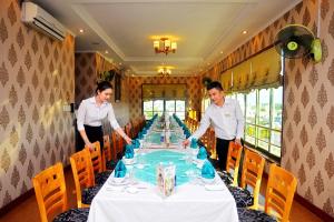 two men standing around a table in a restaurant at Central Hotel in Quảng Ngãi