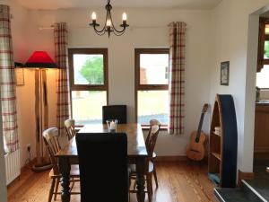 a dining room with a table and a guitar at Kesh Lakeside Cottage in Kesh