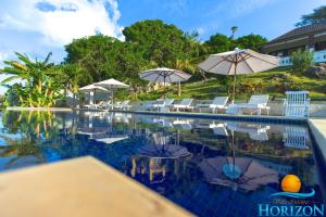 a swimming pool with chairs and umbrellas at Villa Infinite Horizon in Amed