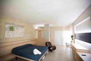 a hospital room with a bed and a desk at Cave Bianche Hotel in Favignana
