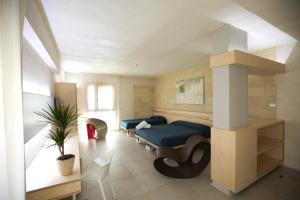 a bedroom with a blue bed and a column at Cave Bianche Hotel in Favignana