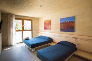 a room with two beds and a window at Cave Bianche Hotel in Favignana