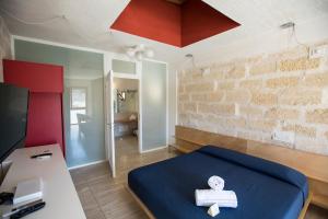 a room with a bed with a cross on it at Cave Bianche Hotel in Favignana