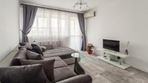 ein Wohnzimmer mit zwei Sofas und einem Fernseher in der Unterkunft Bright House in Bukarest