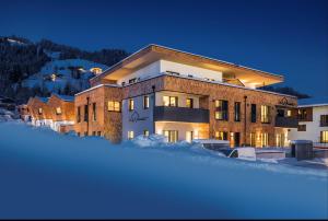 duży budynek w śniegu w nocy w obiekcie Das Heimsitz w mieście Brixen im Thale