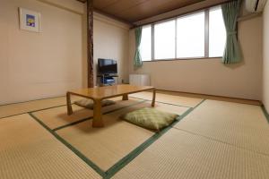 a living room with a table and a large window at Suimeiso in Oshu