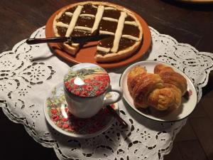 una mesa cubierta con un pastel y una taza de café en La Fattoria di Valentina, en Pomarance