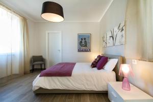 ein Schlafzimmer mit einem Bett und einem Tisch mit einer Lampe in der Unterkunft Apartments La Lombarda Centro Storico Stresa in Stresa