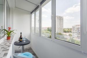 Zimmer mit Fenstern und einem Tisch mit einer Flasche Wein in der Unterkunft Bright House in Bukarest