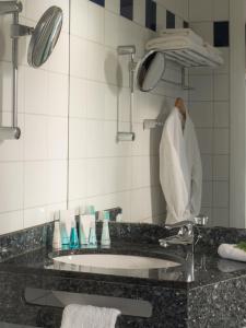 a bathroom counter with a sink and towels at Eurostrand Resort Lüneburger Heide in Fintel