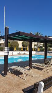 a swimming pool with lounge chairs and a pavilion at Villa Galleria in Perivolia