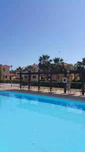 a large blue swimming pool with benches in the background at Villa Galleria in Perivolia