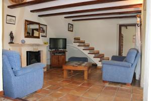sala de estar con 2 sillas azules y TV en Valle Verde en Benitachell