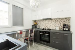 eine Küche mit Spüle und Herd Oberer Backofen in der Unterkunft Bright House in Bukarest + 7 Fotos