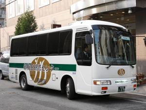 a white bus parked in a parking lot at S.Training Center Hotel Osaka in Osaka