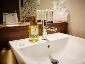 a bathroom sink with a bottle of oil on it at S.Training Center Hotel Osaka in Osaka