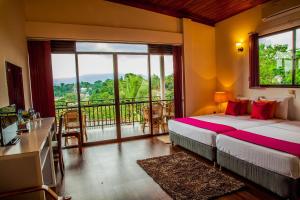 a bedroom with a bed and a balcony with a view at The Tenthola in Kandy