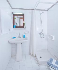 a white bathroom with a sink and a shower at Panorama-Seaview Studios & Apartments in Hersonissos
