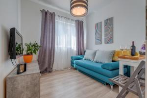 斯普利特Chris's condo的客厅里有一张蓝色的沙发和一张桌子