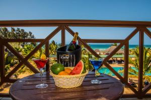 uma mesa com uma cesta de frutas e copos de vinho em South Beach Resort em Dar es Salaam