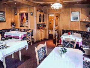 a restaurant with two tables and chairs and a dining room at Garni Gabrieli in Corvara in Badia