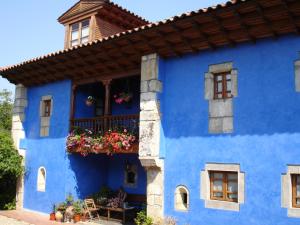 a blue house with flowers in the window at El Ama De Llaves in Hontoria