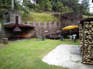 - un bâtiment en pierre avec un banc et un parasol dans l'établissement U Janečků, à Teplice