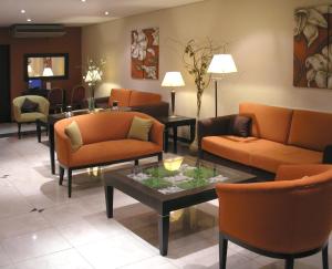 a waiting room with orange couches and a table at Ayacucho Palace Hotel in Buenos Aires