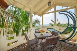 un patio con tavolo, sedie e altalena di ביקתות נוף הגליל a Ya‘ara