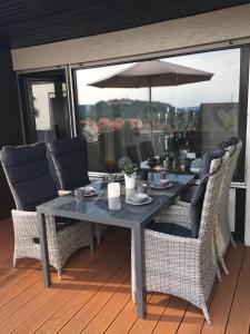 a table with chairs and an umbrella on a deck at Harzhome in Herzberg am Harz