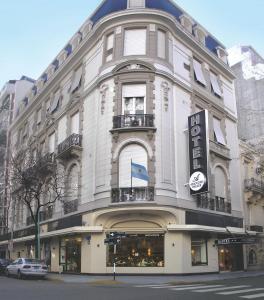 um grande edifício branco na esquina de uma rua em Ayacucho Palace Hotel em Buenos Aires