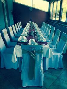 un lungo tavolo con tavoli bianchi e sedie bianche di Lugarnica a Zagabria