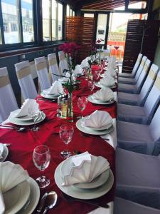 uma mesa longa com pratos vermelhos e brancos e taças de vinho em Lugarnica em Zagreb